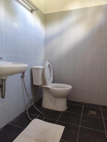 a bathroom with a toilet and a sink at Calishores Beachfront Resort in Morong
