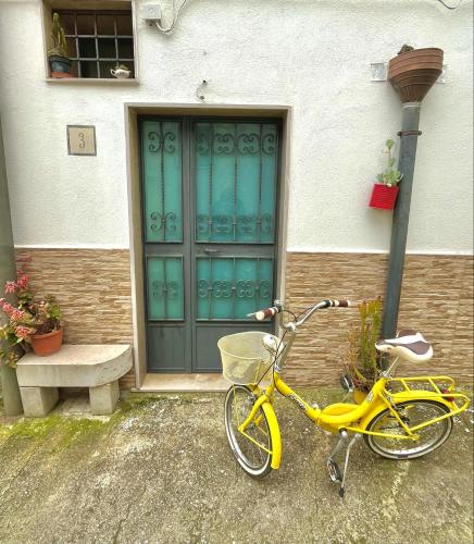 a yellow bike parked in front of a house at Patanella Wine in Spinazzola