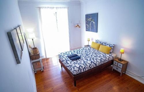a bedroom with a bed with blue and yellow pillows at Lisbonera Guest House in Lisbon