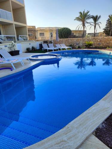 a swimming pool with blue water in a resort at Infinity view residence in Sannat
