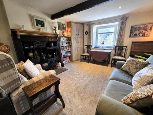 a living room with a couch and a fireplace at Crosland Cottage in Holmfirth