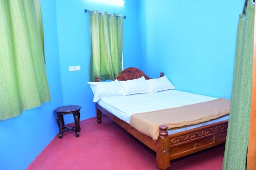 a bedroom with a bed with blue and green walls at Greenfields Pondicherry- An Eco-friendly farm stay in Villianur