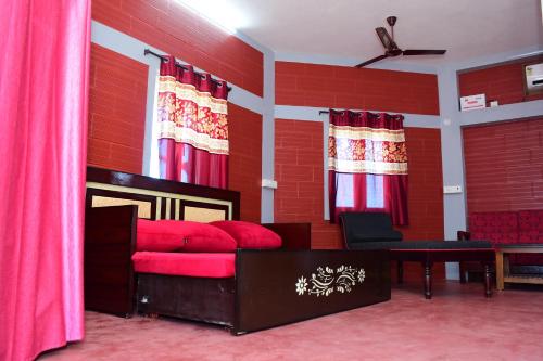 a living room with red walls and a red couch at Greenfields Pondicherry- An Eco-friendly farm stay in Villianur