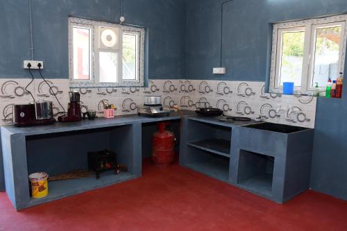 a kitchen with blue counters and a red floor at Greenfields Pondicherry- An Eco-friendly farm stay in Villianur