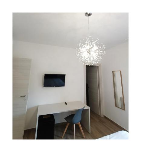 a white desk with a blue chair and a chandelier at La Principessa Nera B&B in Ostra
