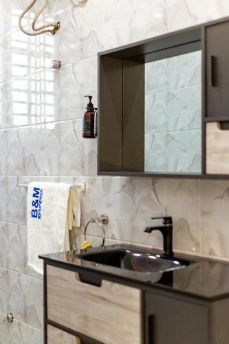 a kitchen counter with a sink and a mirror at B&M residence in Dawhwenya