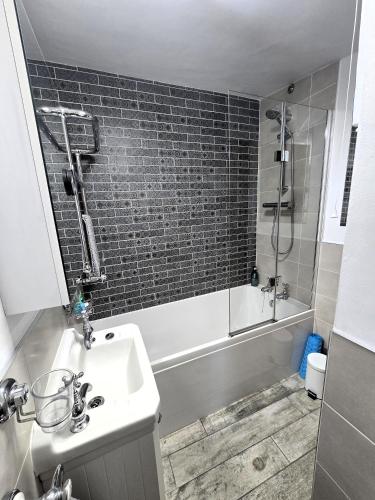 a bathroom with a sink and a shower and a tub at Crosland Cottage in Holmfirth