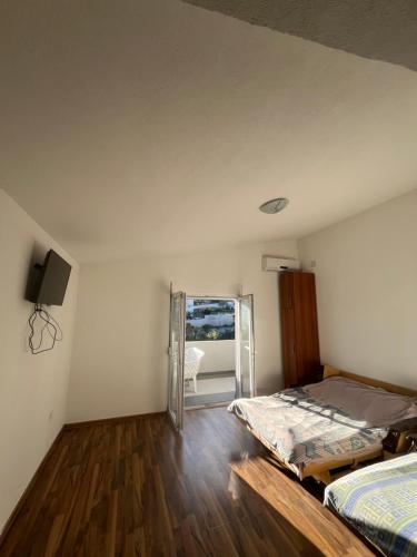 a bedroom with two beds and a sliding glass door at Apartmani Dasic in Sutomore