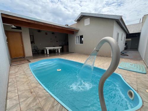 una piscina con una fuente de agua en un patio en Recanto Belmonte, en Olímpia