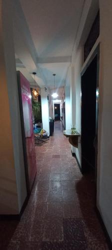 a hallway of a building with a long hallwayngth at Hotel El Barcino in Neiva