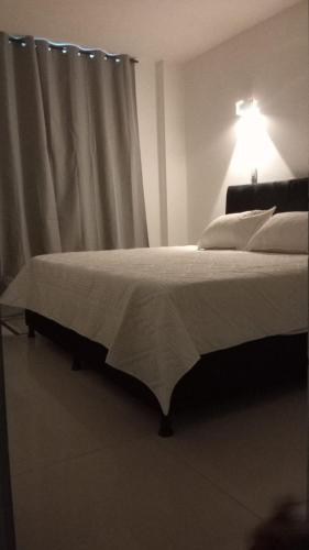 a bedroom with a bed with a light on it at MonteClaro de Fusa in Fusagasuga