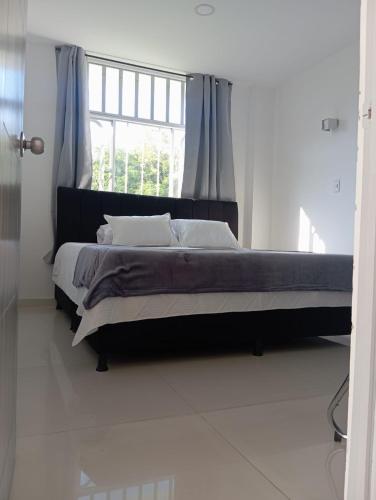 a bedroom with a large bed with a window at MonteClaro de Fusa in Fusagasuga
