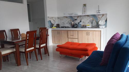 a kitchen with a table and a red ottoman at MonteClaro de Fusa in Fusagasuga