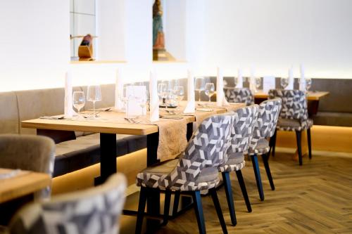 a row of tables and chairs with wine glasses on them at Hotel Alpina in Obertauern