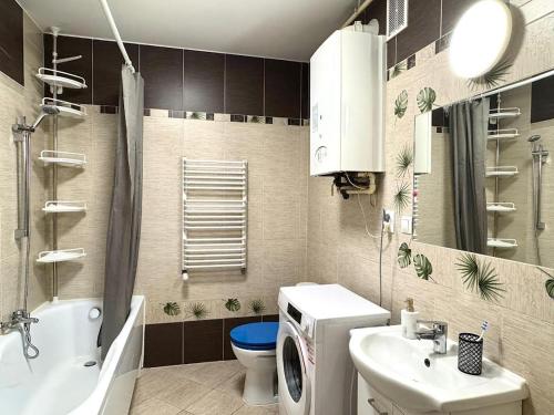 a bathroom with a toilet sink and a washing machine at Taras Słoneczny in Kielce