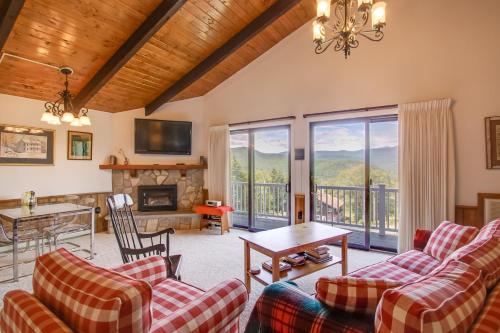a living room with couches and a fireplace at Mountaintop Condo with Great Mt Washington View in Glen