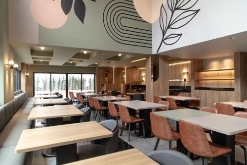 a dining room with tables and chairs at Slim Curitiba Alto da XV in Curitiba