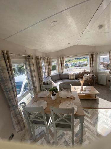 a living room with a table and chairs in a caravan at Westfield Lodge Retreat-Sleeps 6-Pet Friendly in Carnforth