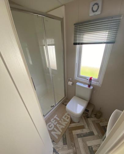 a bathroom with a toilet and a glass shower at Westfield Lodge Retreat-Sleeps 6-Pet Friendly in Carnforth