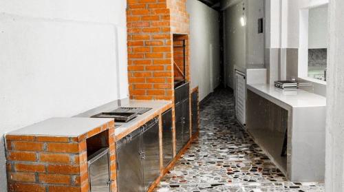 una cucina con muro di mattoni e bancone di Cabaña CasaBlanca a Santa Marta