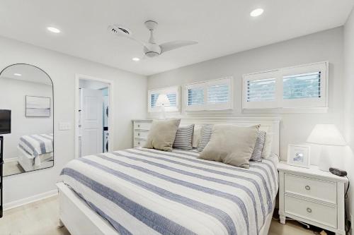 a white bedroom with a bed and a mirror at Sea Colony - 4203 Rally in Bethany Beach