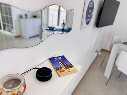 a table with a book and a mirror on it at Casa Isa in San Leone