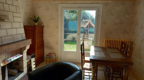 un salon avec une table et une fenêtre dans l'établissement Charmante Maison avec jardin entre Deauville et Honfleur, à Saint-Gatien-des-Bois