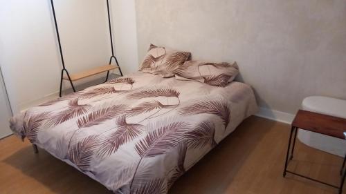 - un lit avec une couette et des feuilles de palmier dans l'établissement Charmante Maison avec jardin entre Deauville et Honfleur, à Saint-Gatien-des-Bois