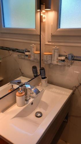 une salle de bain avec un lavabo blanc et un miroir dans l'établissement Charmante Maison avec jardin entre Deauville et Honfleur, à Saint-Gatien-des-Bois