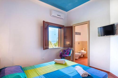 1 dormitorio con cama, ventana y baño en Villa Acquamarina - 300 meters from the sea, en Scopello