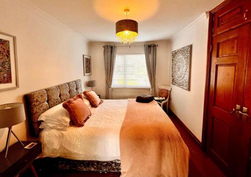 a bedroom with a bed and a window at Comfy Cottage in Ballymena