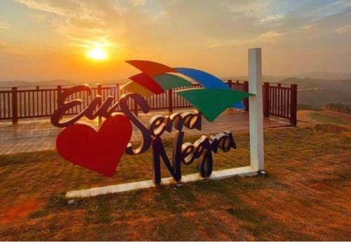 a sign that says love with hearts and umbrellas at Apartamento no centro da cidade in Serra Negra