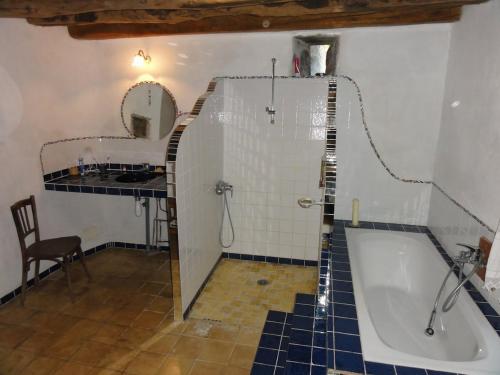 une salle de bain avec une baignoire, un lavabo et un miroir dans l'établissement L'abeille verte, à La Celle-sous-Gouzon