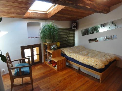 une chambre avec un lit et une chaise dans une pièce dans l'établissement L'abeille verte, à La Celle-sous-Gouzon