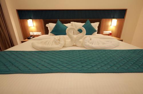 two towels are made to look like swans on a bed at Viraj Retreat in Munroe Island