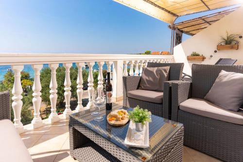 a balcony with chairs and a table with a view of the ocean at Apartman Petra s pogledom na more in Banjol