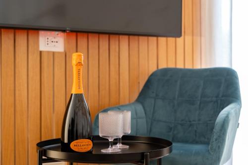 a bottle of wine on a table next to a chair at New Elegance Suites Guesthouse in Oristano