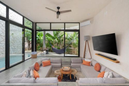 a living room with a couch and a flat screen tv at Bohemian Bliss Villa with Private Pool & Concierge 1A in Tulum