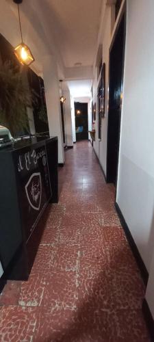a hallway with a red tile floor in a building at Hotel El Barcino in Neiva