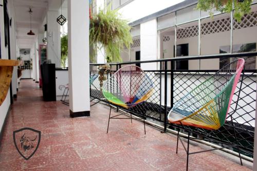 a balcony with two chairs and a fence at Hotel El Barcino in Neiva