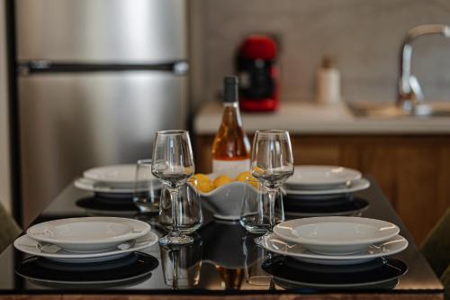 a table with plates and wine glasses on it at 1864 Apartments in Zakynthos