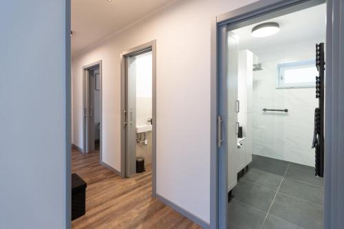 a bathroom with a door open to a bathroom with a toilet at Hóvirág Apartman in Hódmezővásárhely