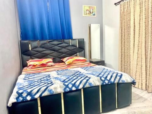 a bedroom with a bed with a blue curtain at Vi Homes-A 4BHK HomeStay in Jaipur