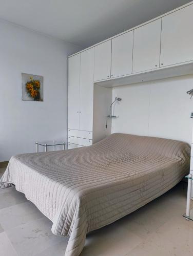 - une chambre avec un grand lit et des placards blancs dans l'établissement Bright and spacious seaside studio, à Roquebrune-Cap-Martin