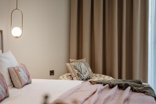 a bedroom with a bed with pillows and a window at 1864 Apartments in Zakynthos