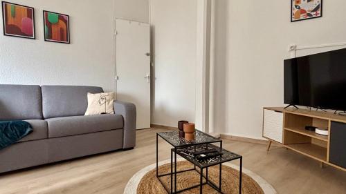 a living room with a couch and a television at Le refuge autunois in Autun