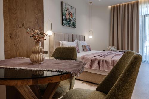 a bedroom with a bed and a table with chairs at 1864 Apartments in Zakynthos