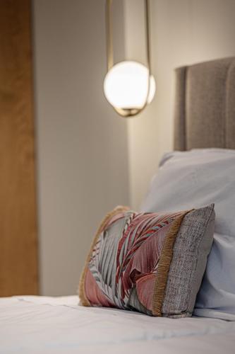 a pillow sitting on top of a bed with a light at 1864 Apartments in Zakynthos