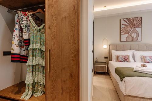 a bedroom with a bed and a dress hanging on a closet at 1864 Apartments in Zakynthos