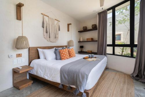 a bedroom with a large bed with orange and gray pillows at Bohemian Bliss Villa with Private Pool & Concierge 1A in Tulum